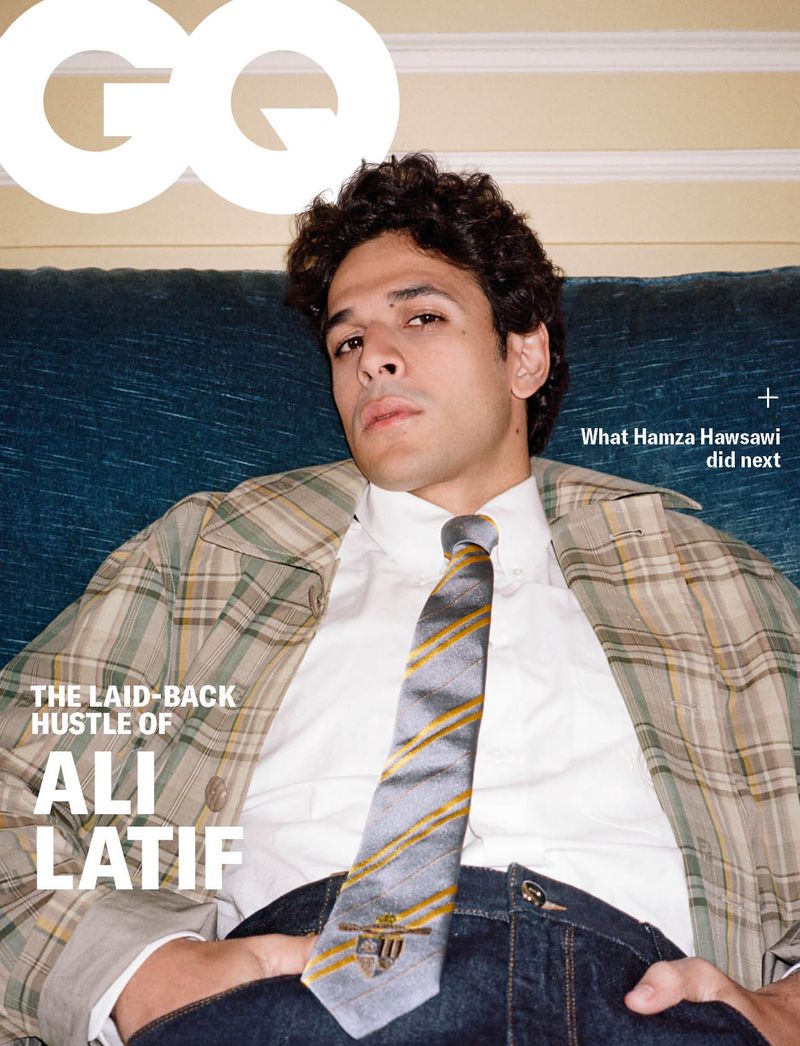 Magazine cover featuring a portrait of a man in a white shirt, patterned tie, and a plaid jacket, reclining against a teal surface.
