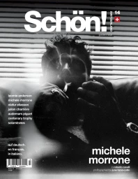 Black and white magazine cover featuring actor Michele Morrone smoking in front of horizontal window blinds.