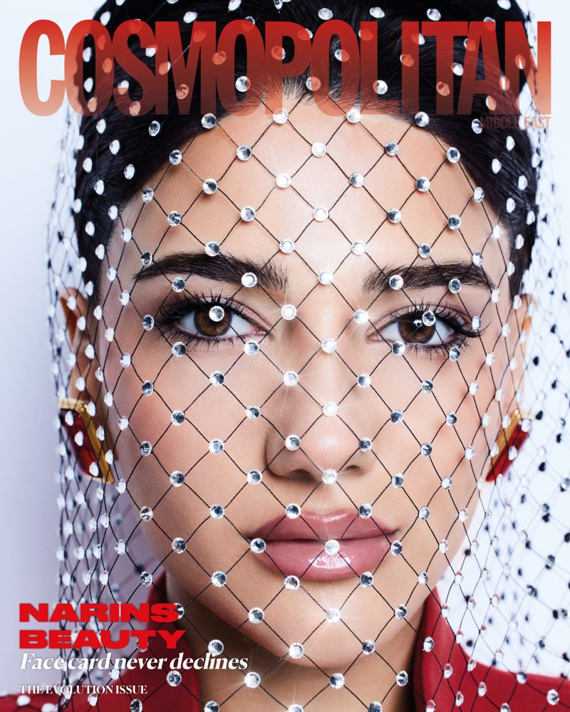 Magazine cover featuring a woman with a beaded net veil, wearing red attire and gold earrings, with 'Cosmopolitan' text at the top.