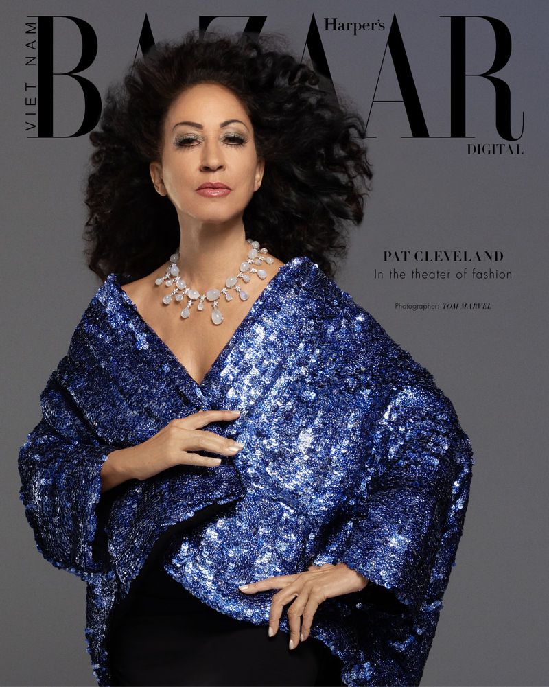Fashion editorial shot of an adult female model, Pat Cleveland, wearing a shiny blue sequined jacket and a statement necklace for Bazaar.