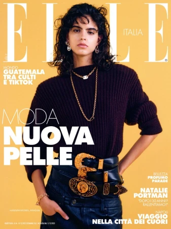 Elle Italia magazine cover featuring a woman with curly dark hair, wearing a dark sweater, leather pants, and multiple belts with gold buckles.