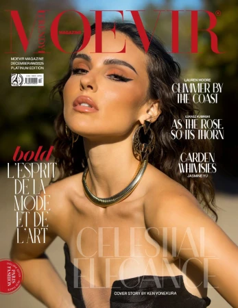 Magazine cover of a woman with brunette hair wearing gold collar necklace and earrings in a strapless black top.