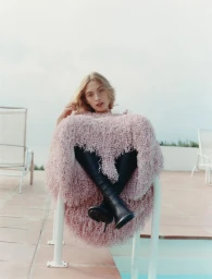 Model in textured pink garment seated near a pool for The Times Magazine UK December 2025 Cover