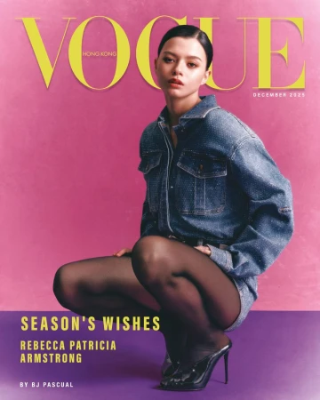 Woman wearing denim shirt and black heels squatting against pink background for Vogue Hong Kong cover