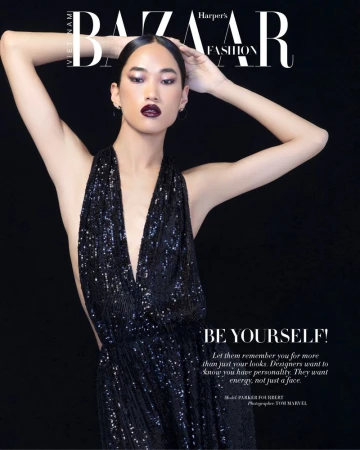 Model Parker Foubert posing in a plunging black sequin halter dress against a black background for a magazine cover.