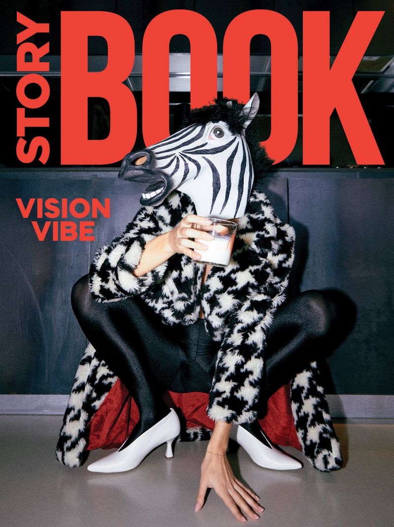 Person wearing a zebra mask and fur coat, squatting with high heels, holding a glass with a red 'BOOK' logo in the background.