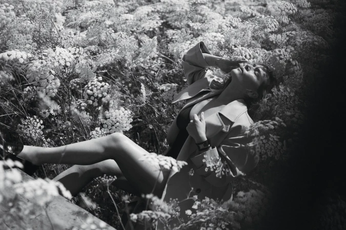 Kate Winslet reclining amidst a dense field of tall wildflowers for Vogue Australia, photographed in dramatic black and white.