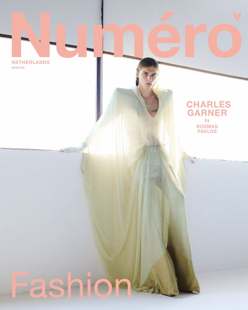 Fashion magazine cover featuring a slender adult woman in a long flowing dress, posing in front of a window with bright natural light.