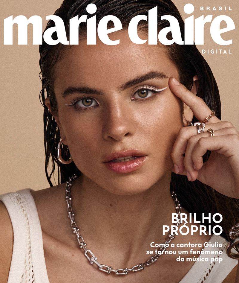 Close-up magazine cover featuring a woman with a silver chain necklace, rings, and white eyeliner, with the magazine title visible.