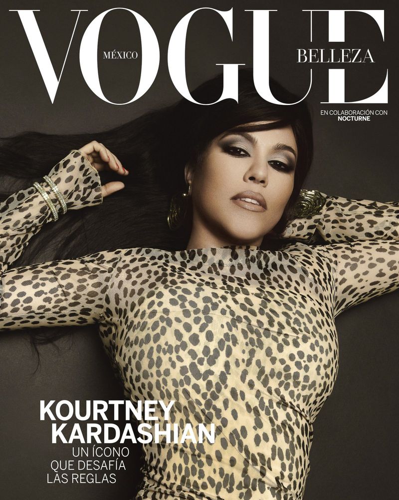 Vogue México cover featuring Kourtney Kardashian in a leopard-print dress, bold eye makeup, and jewelry against a dark gray background.