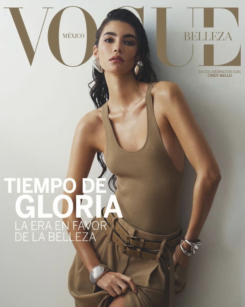 Vogue Mexico cover featuring a brunette model in a tan tank top and skirt, posing against a neutral wall. Beauty and fashion theme.