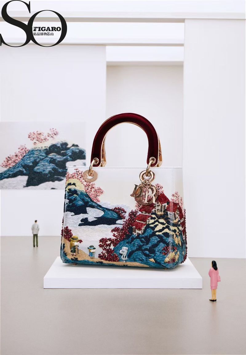 Exquisite Dior Lady D-Joy Bag showcasing intricate landscape embroidery, miniaturized figures, and placed on a white pedestal in a studio.