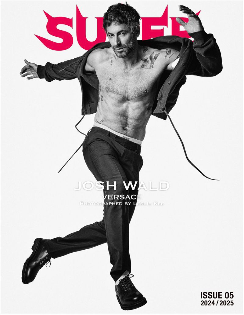 Magazine cover featuring a shirtless male model in motion, wearing pants and shoes, with a pink logo and white background. 