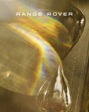 Close-up of a teardrop crystal with luminous rainbow prism light flare and Range Rover typography.