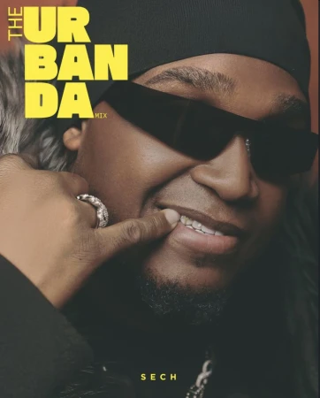 Close-up portrait of music artist Sech wearing black sunglasses and a beanie, pointing at his smile for The Urban Da Mix magazine cover.