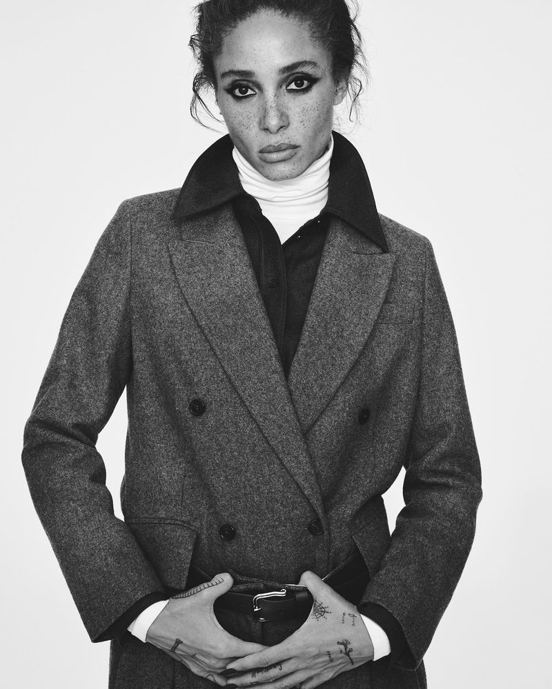 Model Adwoa Aboah wearing a grey double-breasted blazer and turtleneck against a plain white background for British Vogue.