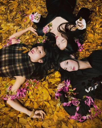 Three female models lying among scattered yellow leaves and pink flowers for Time Magazine photography by Poyenchen