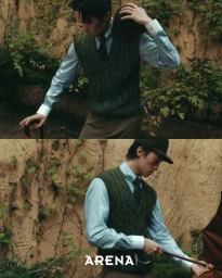 Model Jiaxuan Yang wearing a green cable-knit vest, light blue shirt, tie, and bowler hat against an ivy-covered wall.
