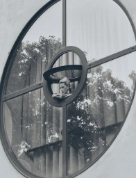 Model Liza Ostanina leaning through a circular window aperture for Grazia International