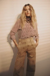 Model Meg Dmitruk wearing a striped button-down shirt, neck scarf, and wide-leg trousers for Veronica Beard.