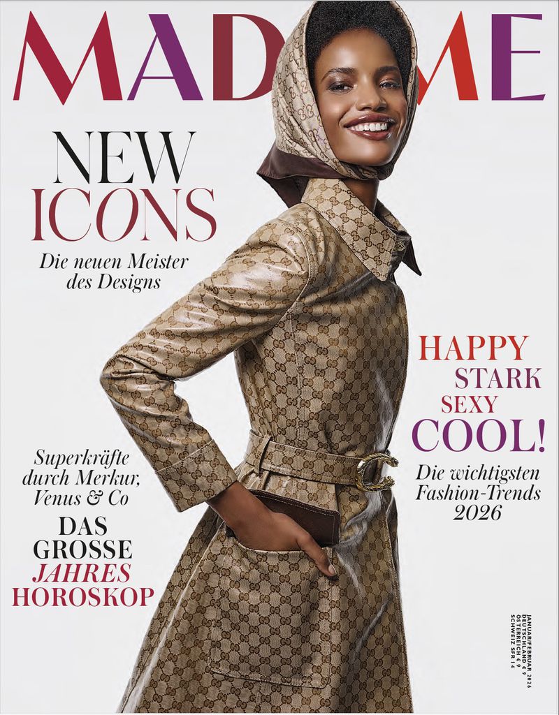 Magazine cover featuring an adult female model wearing a beige Gucci trench coat and headscarf, smiling against a bright background.