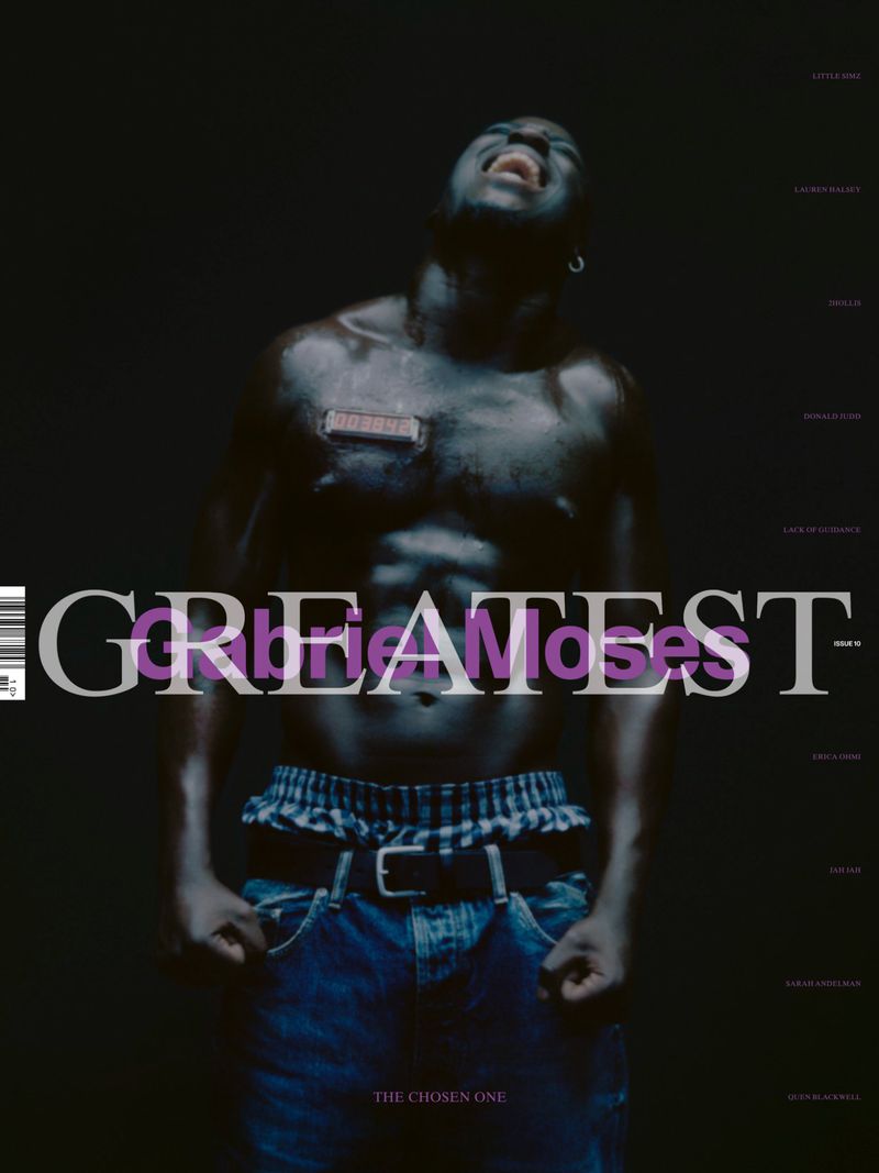 Shirtless Black male model with clenched fists looks upward in dim studio light wearing jeans; text overlay features brand and magazine details.