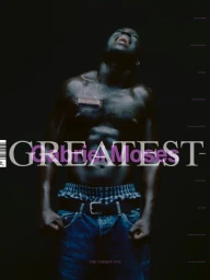 Shirtless Black man with glistening skin wearing denim jeans against a dark background for Greatest Magazine cover portrait
