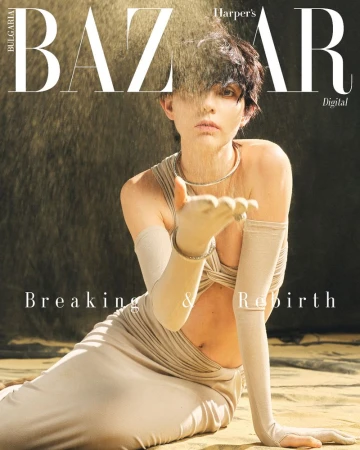 Fashion magazine cover featuring a woman in a beige dress with long gloves, holding sand, against a golden background with bold typography.