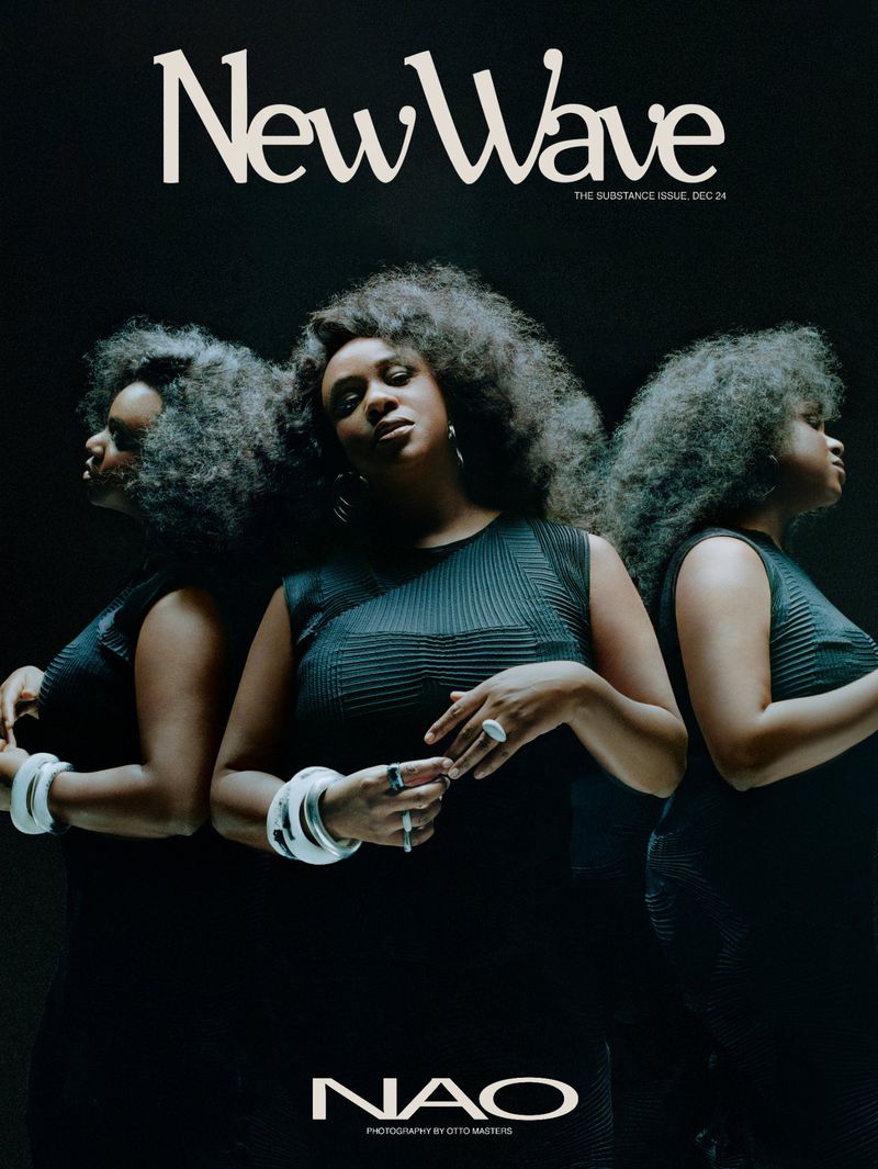 Magazine cover featuring a Black woman with large afro, wearing a black dress and silver bracelets, against a dark backdrop.