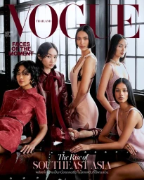 Five female models posing together for a fashion magazine cover in front of large windows.