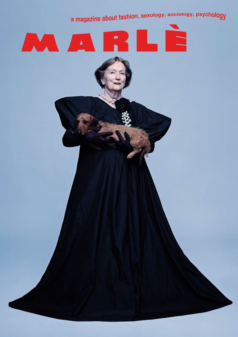 Magazine cover featuring an elderly woman in a black gown holding a dachshund against a light blue backdrop with the title 'MARLE' in red.