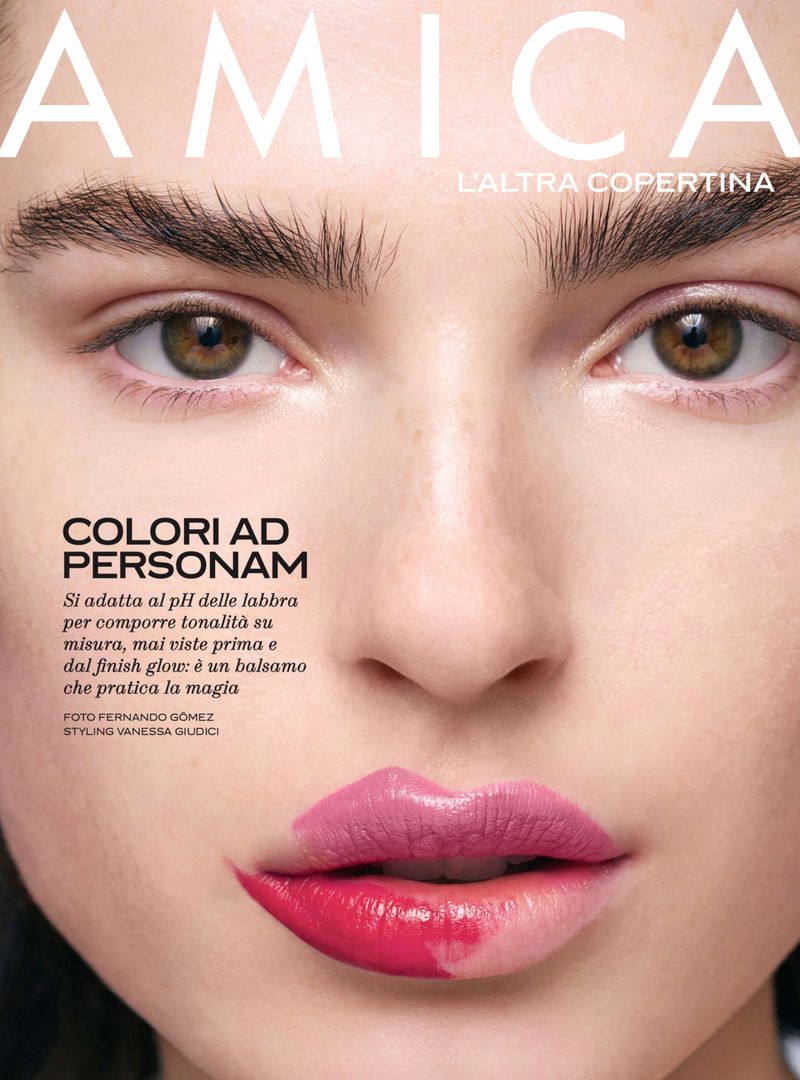 Close-up portrait of a woman on a magazine cover featuring the brand Amica, showcasing two-tone lipstick with pink and red hues, and the phrase 'Colori ad Personam'.