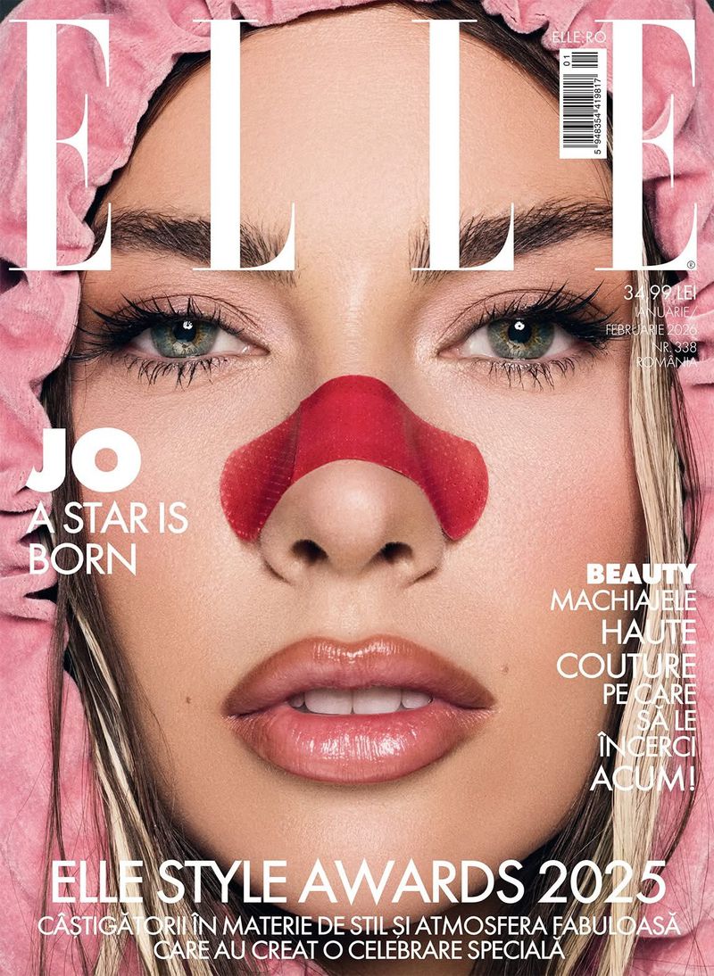 Close-up of a woman's face on the cover of Elle magazine featuring fair skin, green eyes, pink head covering and a red pore strip on nose.