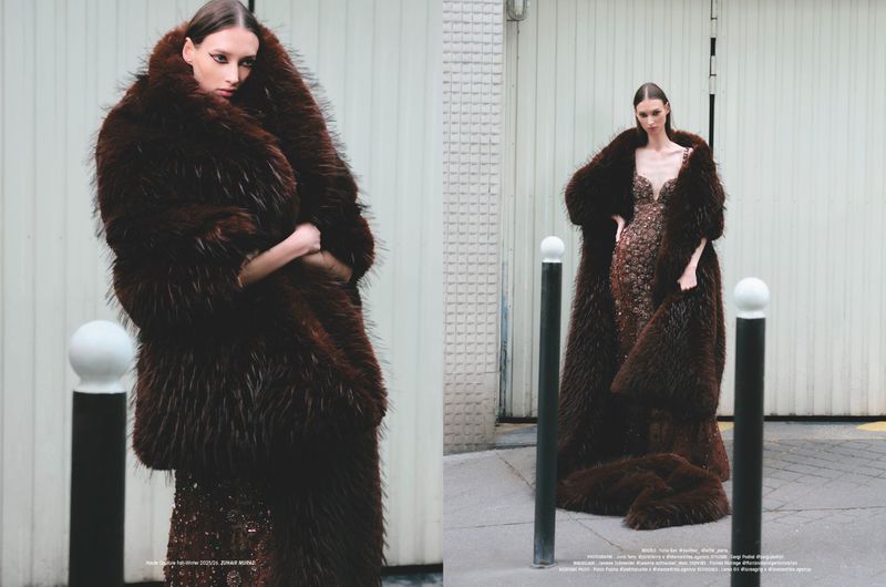 Fashion editorial shot of a model in a brown sequin dress and a large fur coat posing on a city street near a white building.