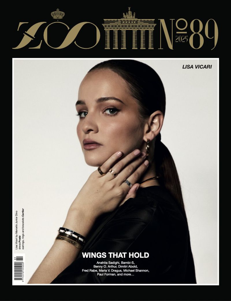 Magazine cover featuring a portrait of Lisa Vicari with a light grey background. Gold details including the magazine title and logo.