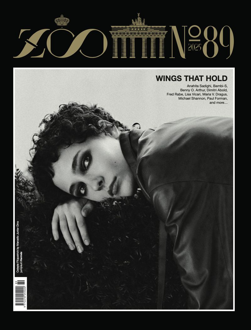 Black and white magazine cover featuring a portrait of a curly-haired person with a leather jacket on a dark, leafy background.