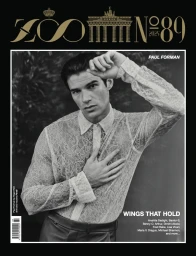 Black and white magazine cover featuring Paul Forman in a sheer lace collared button-down shirt with hand to head.