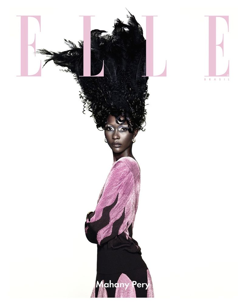 Elle Brazil cover featuring a fashion model with extravagant black feather hair posing in a pink top and black skirt against a white backdrop.