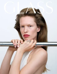 Model Leanne De Haan resting her hands on a metal studio bar against a white background for Glass Magazine.
