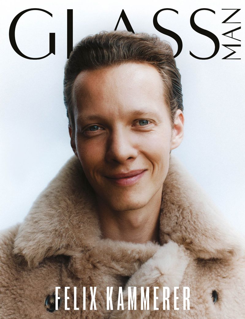 Felix Kammerer cover portrait for Glass Man magazine, wearing a beige fur coat, smiling against a bright gradient background.