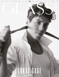 Portrait of actor Lukas Gage pulling a tie against his neck in a black and white Glass Man magazine cover photo