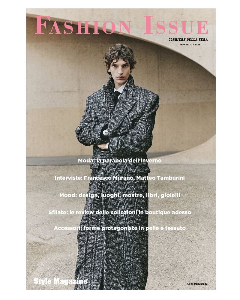 Magazine cover featuring a young adult male model in an oversized tweed coat, posing outdoors against a textured concrete wall backdrop.