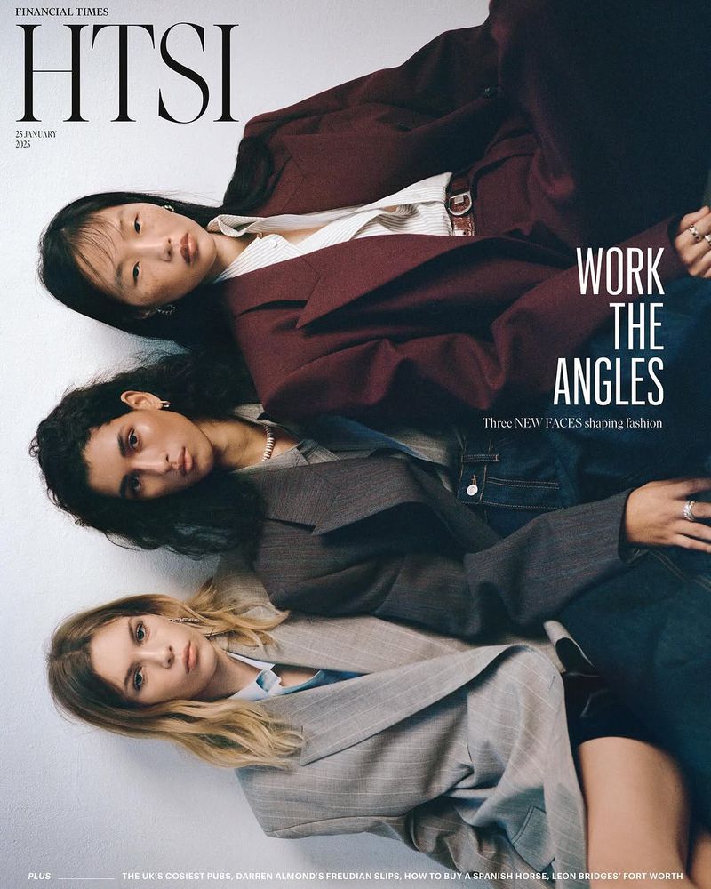 Editorial fashion shot featuring three diverse women wearing blazers, styled in an angular, eye-level studio composition.