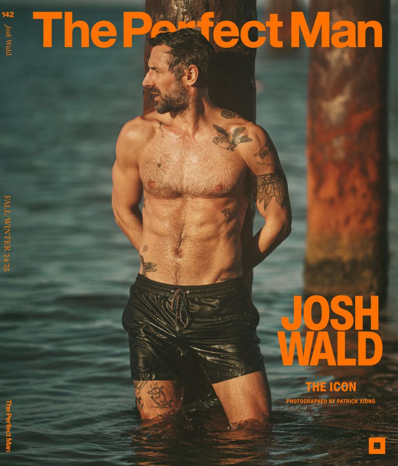 Magazine cover featuring a shirtless adult male with tattoos, standing in shallow water near wooden posts, fashion, beauty, celebrity content.