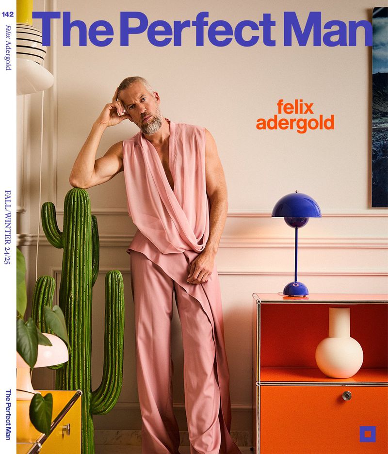 Fashion magazine cover featuring a man in pink outfit posing next to a cactus, with modern furniture and bold typography.