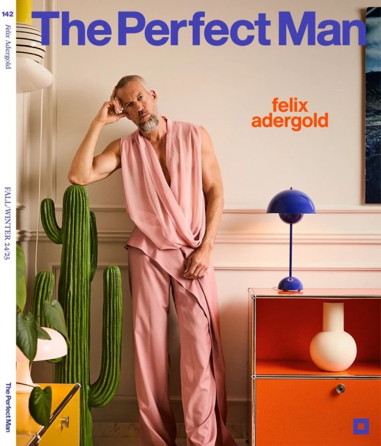 Fashion magazine cover featuring a man in pink outfit posing next to a cactus, with modern furniture and bold typography.