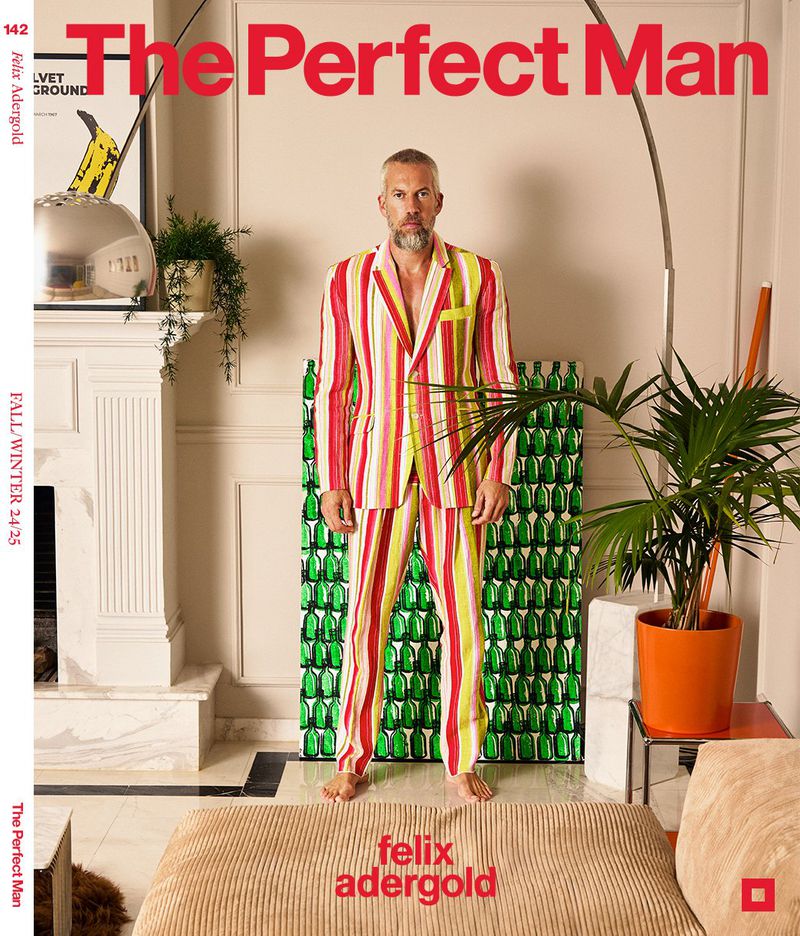 Magazine cover featuring a stylish adult male in a striped suit, set against a neutral interior with plants and design elements.