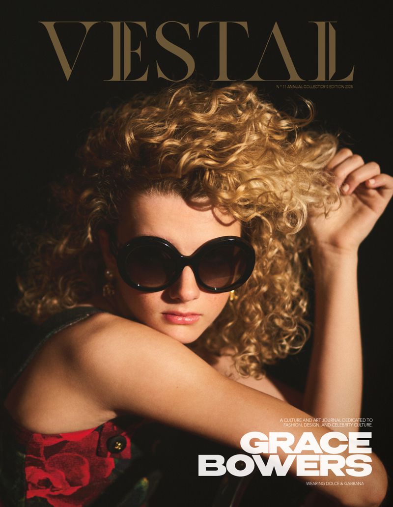 Magazine cover featuring a woman with blonde curly hair, sunglasses, and a floral dress against a dark backdrop, with 'VESTAL' in bold text.