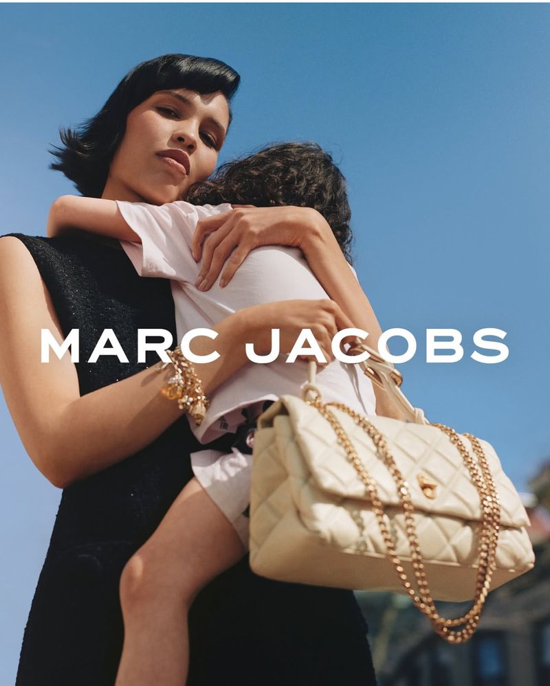 Nara Smith holding a child in a campaign for Marc Jacobs Mothers Day 2025, featuring a quilted cream handbag.