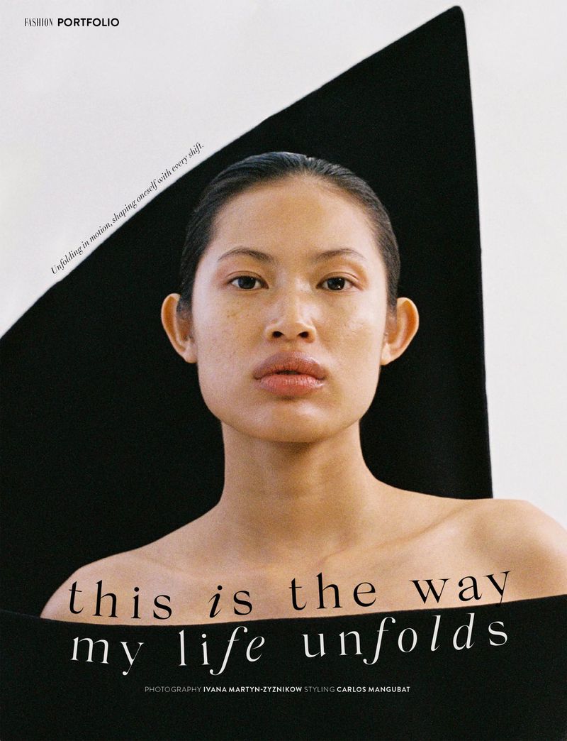 Headshot of a young Asian woman with bare shoulders, clean makeup, and slicked-back hair, posing against a black and white backdrop.